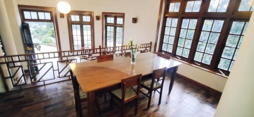 a dining room with a wooden table and chairs at Magnolia Hideout in Nuwara Eliya