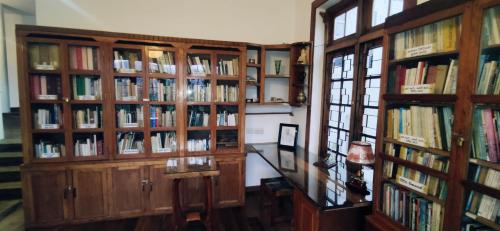 a library with wooden book shelves filled with books at Magnolia Hideout in Nuwara Eliya