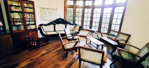 a room with a table and chairs in a library at Magnolia Hideout in Nuwara Eliya