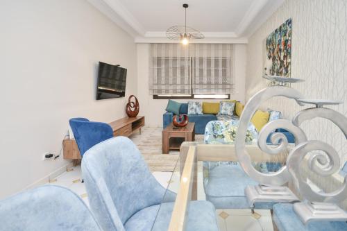 a living room with blue chairs and a couch at Cozy 2 BR Gauthier Oasis in Casablanca