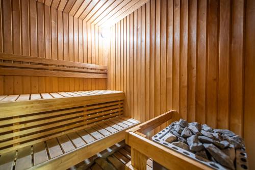 a wooden sauna with two beds and a pile of rocks at Tbilisi Laerton Hotel in Tbilisi City