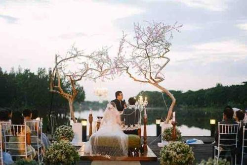 a bride and groom sitting at a table at their wedding at Modern Home in Lakeshore Mexico, Pampanga in Mexico
