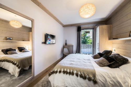 sypialnia z 2 łóżkami i dużym lustrem w obiekcie Résidence Carre Blanc - 2 Pièces pour 6 Personnes 424 w Courchevel