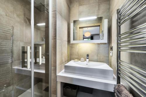W łazience znajduje się biała umywalka i lustro. w obiekcie Résidence Carre Blanc - 2 Pièces pour 6 Personnes 424 w Courchevel