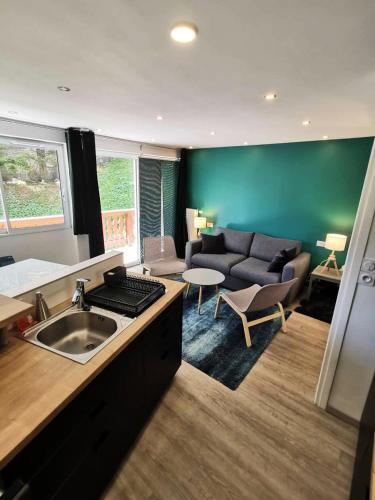 een keuken en een woonkamer met een bank en een tafel bij Résidence Midi - Studio pour 4 Personnes 974 in Vénosc