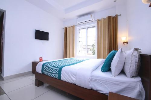 Ambalavayal的住宿－OYO Hotel Pearl View Residency，一间卧室设有一张大床和窗户
