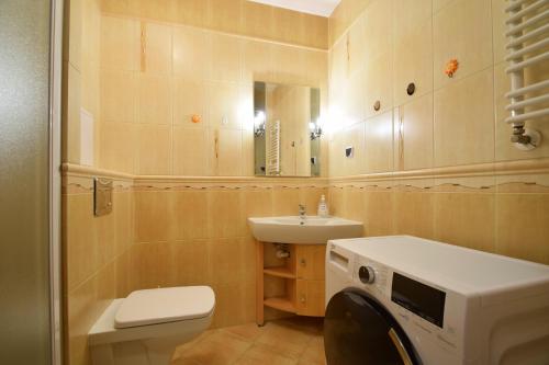 a bathroom with a sink and a washing machine at Apartament 29 Zielone Tarasy Kołobrzeg in Kołobrzeg