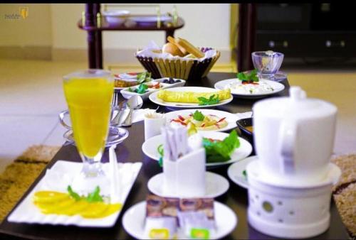 uma mesa com pratos de comida e uma bebida em فندق ميلانا Milana Hotel em Jeddah