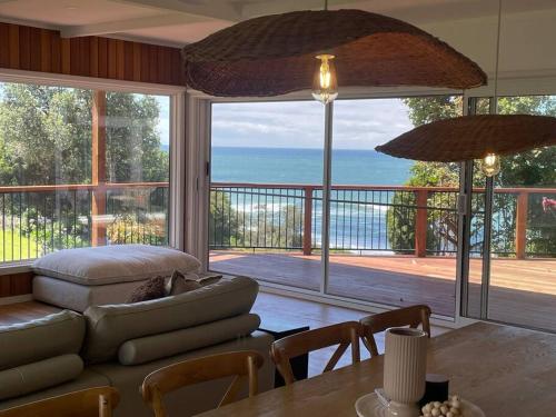 a living room with a couch and a view of the ocean at The Dunes *Beachfront* Lake Tyers Beach in Lake Tyers