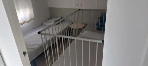 Zimmer mit einem Kinderbett mit einem Bett und einem Tisch in der Unterkunft Camping de Charlieu in Charlieu