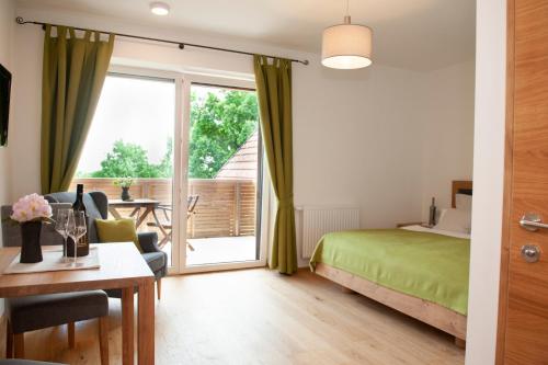a bedroom with a bed and a desk and a window at Weingut Assigal in Leibnitz