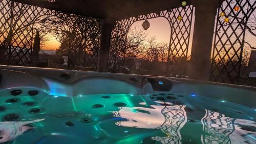 a jacuzzi tub with a sunset in the background at Domaine Les Feuillants in Crouzilles