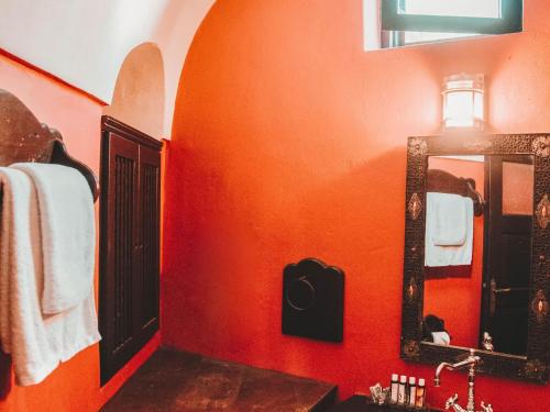 an orange bathroom with a sink and a mirror at Villa in Santorini with Stunning Outdoor Kitchen in Megalokhori