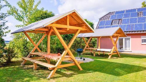 a wooden pavilion with a solar roof on a yard at Ferienpark Neppermin Appartmenthäuser in Neppermin