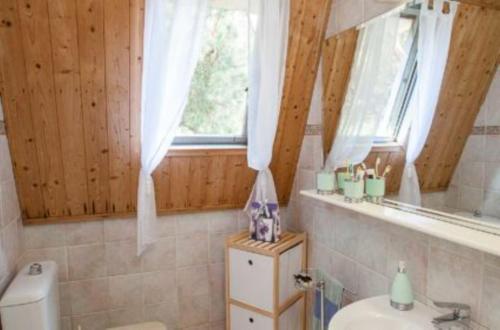 a bathroom with a toilet and a sink and a window at Fantastic three-room penthouse - Beahost Rentals in Rosolina Mare