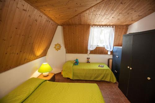 a bedroom with two green beds and a window at Fantastic three-room penthouse - Beahost Rentals in Rosolina Mare