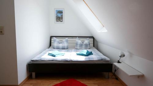 a bedroom with a bed with blue pillows at Dat blaue Huus - Am Tor zum Darß in Pruchten