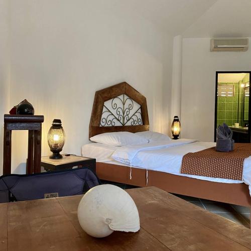 a bedroom with two beds and a table at La Casa Bianca Samui in Amphoe Koksamui