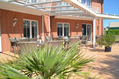 a patio with chairs and tables and a brick building at Hotel Flora in Herzlake