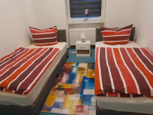 dos camas sentadas una al lado de la otra en una habitación en 70 qm Ferienwohnung mit 2 Schlafzimmern, en Zwickau