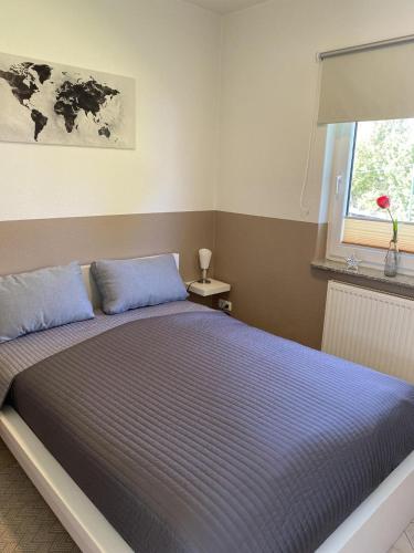 a bedroom with a bed with blue pillows and a window at Villa Baltica Bungalow in Dahme