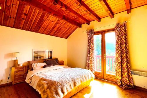 a bedroom with a bed and a large window at CASA-Emmanuelle chalet Guillestre in Guillestre