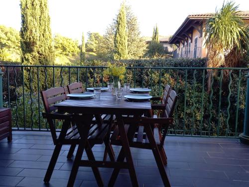 een houten tafel met 4 stoelen op een patio bij Appartement premium T3 résidence piscine in La Croix-Valmer