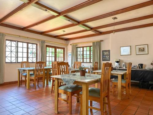 a dining room with wooden tables and chairs at Park Gables Loftus in Pretoria
