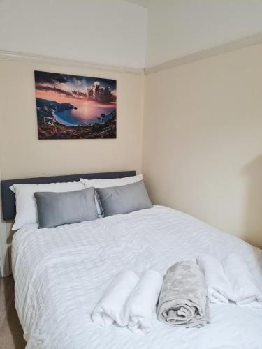 a white bed with towels on it in a bedroom at Genade Apartments - Heaton in Newcastle upon Tyne