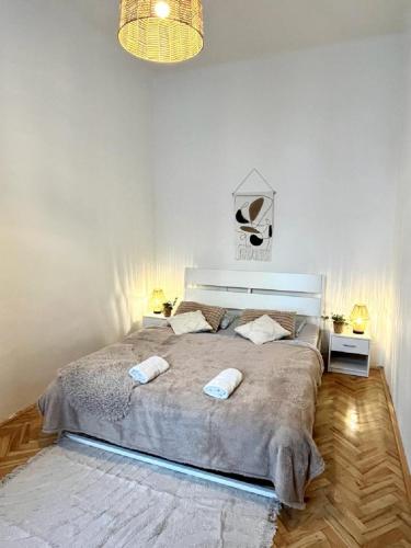 a bedroom with a large bed with two towels on it at Apartment Cecil - Old Town in Bratislava