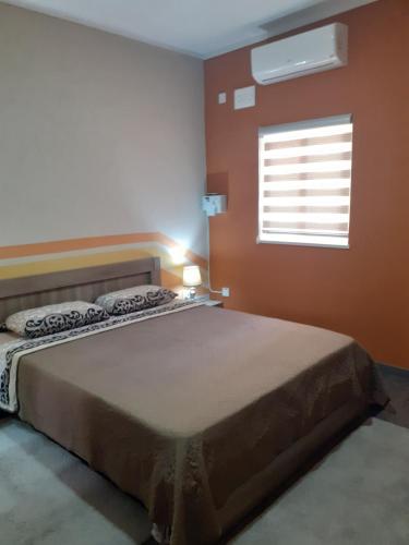 Un dormitorio con una cama grande y una ventana en Cosy Home by the Sea en Birżebbuġa