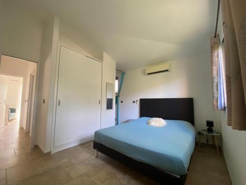ein Schlafzimmer mit einem blauen Bett und einem Flur in der Unterkunft Villa valle longa capicciola in Sainte-Lucie de Porto-Vecchio