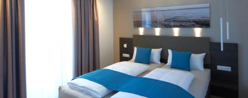 - une chambre avec un lit doté d'oreillers bleus et blancs dans l'établissement ausZeit, à Hagnau am Bodensee