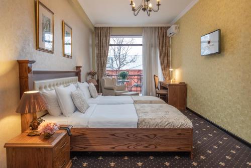 a hotel room with a large bed and a window at Tbilisi Laerton Hotel in Tbilisi City
