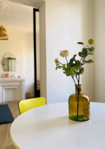 un vase jaune avec des fleurs sur une table blanche dans l'établissement Minimalistic style of Baille by Weekome, à Marseille