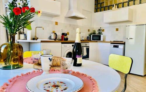 eine Küche mit einem Tisch mit einem Teller und einer Flasche Wein in der Unterkunft Minimalistic style of Baille by Weekome in Marseille