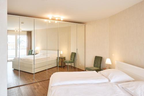 een slaapkamer met een bed en een spiegelwand bij Nordico, FeWo 8 in Duhnen