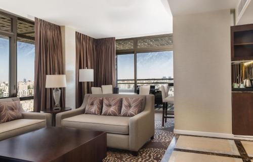 a living room with a couch and a table at Mövenpick Hotel Amman in Amman