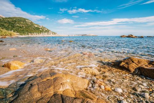 una playa con rocas en el agua en un día soleado en VILLA ISOLOTTO a 150 m dal mare, en Santa Maria Navarrese