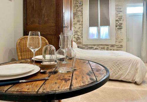 a wooden table with wine glasses and plates on it at Studio 29 in Nîmes
