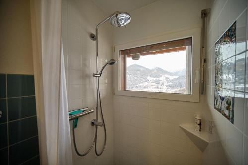 łazienka z prysznicem i oknem w obiekcie Chasa Panorama w mieście Scuol