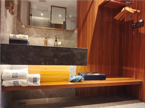 a bathroom with a sink and a counter with towels at LanOu Hotel Lianyungang Donghai High-speed Railway Station Crystal City in Donghai