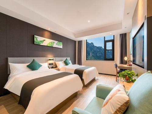 a hotel room with two beds and a couch at Thank Inn Chain Jiaozuo Qinyang Qinbei Industral Cluster in Qinyang