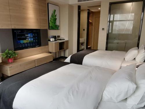 Yongcheng的住宿－尚客优品商丘永城金博大广场酒店，酒店客房设有两张床和一台平面电视。