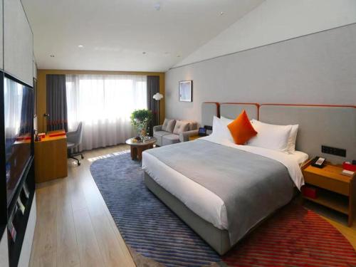 a hotel room with a large bed and a television at LanOu M Hotel Shangxing Luxun's Hometown in Shaoxing