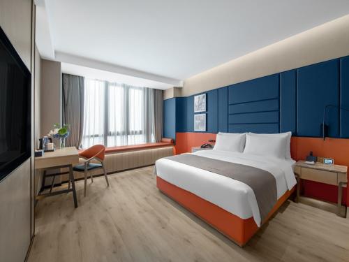 a hotel room with a large bed and a desk at LanOu Hotel Changsha Wuyi Square in Changsha
