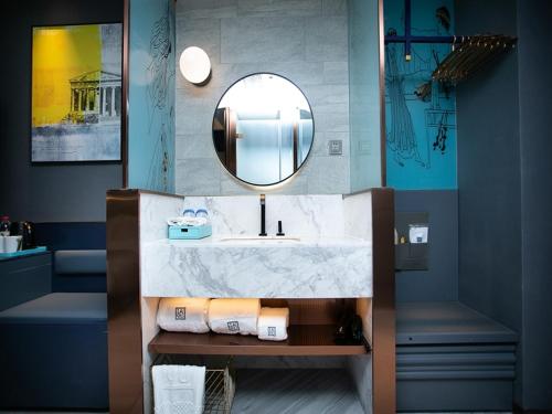 a bathroom with a sink and a mirror at LanOu Hotel Huai'an Lianshui High-Speed Railway Station Yanhuang Avenue in Lianshui