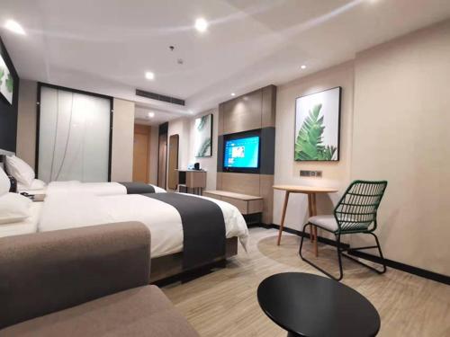 een hotelkamer met een groot bed en een televisie bij Thank Inn Chain Heyuan Zijin Baocheng Commercial Plaza in Zijin