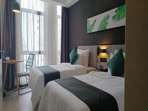 een hotelkamer met 2 bedden en een tafel bij Thank Inn Chain Yingtan Guixi Eagle Avenue Shengfeng in Guixi