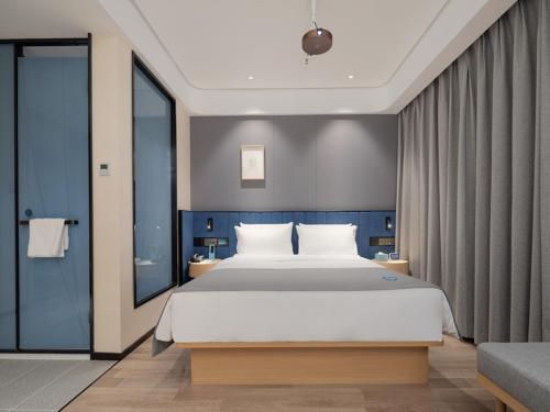 a bedroom with a large bed and a large window at LanOu Hotel Yangquan Gymnasium in Yangquan